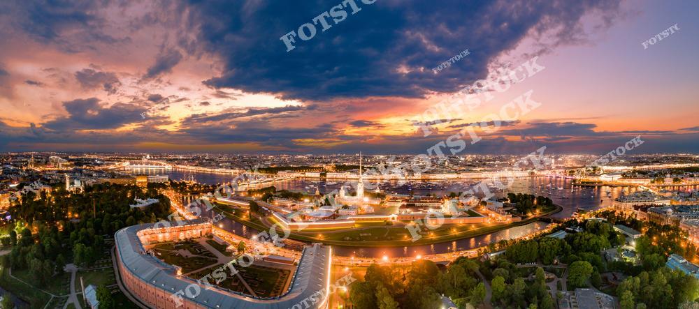 Панорамная фотография Санкт-Петербурга с высоты птичьего полета, на которой видны Петропавловская крепость, Заячий остров, Васильевский остров, центральные каналы и мосты города. Снимок с дрона позволяет увидеть архитектуру исторического центра, красоту Невы и панораму городских каналов, создавая впечатление масштабного городского пейзажа. Фотография передает атмосферу северной столицы России, подходит для туристических публикаций, фотостоков, оформления интерьеров, рекламы и материалов о путешествиях. Вид с высоты раскрывает уникальные панорамные перспективы Санкт-Петербурга, мосты и реки, а также гармоничное сочетание архитектуры и городской среды.